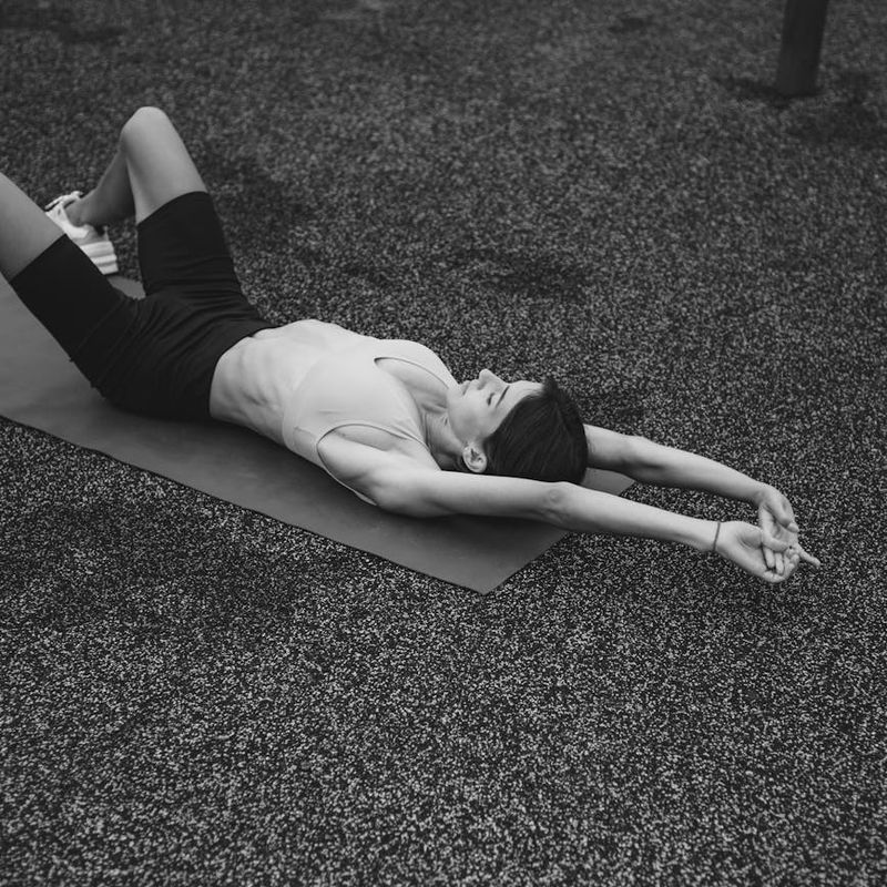Overhead view of a person lying in a relaxing yoga pose on a mat.